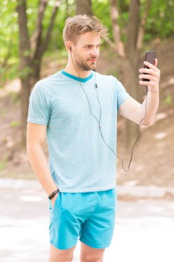 Fitness hedeflerine ulaşmak için tasarlanmış telefon. Sporcu cep telefonu açık video arama yapma. Onun telefonda hoparlör modu kullanarak atletik adam. Sizi her yerde bağlı tutan telefon