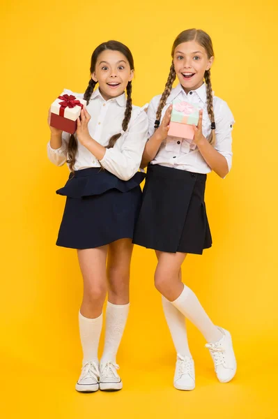 Best pupils award. Holiday celebration. Sharing gifts. Rewarding excellent pupils. Girls opening gifts yellow background. Classmates tidy pupils open gifts boxes. Educational program for gifted kids — Stock Photo, Image