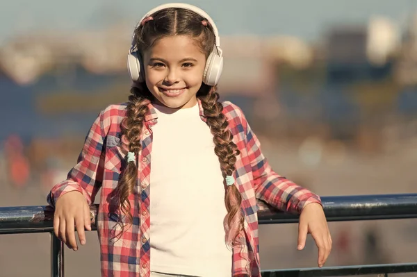 Cieszy się swoją ulubioną muzyką. Dziewczynka w słuchawkach stereo. Dziewczynka słuchająca muzyki. Dziewczynka z bezprzewodowymi słuchawkami. Urocza dziewczynka wykorzystująca technologię do wypoczynku lub edukacji — Zdjęcie stockowe