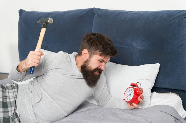 Duerme más. Concepto de salud. Etapas del sueño. Hombre despierto infeliz con alarma sonando. Aunque duerma puede despertar sintiéndose como si no durmiera en absoluto. Tipo irritado destruir molesto reloj —  Fotos de Stock