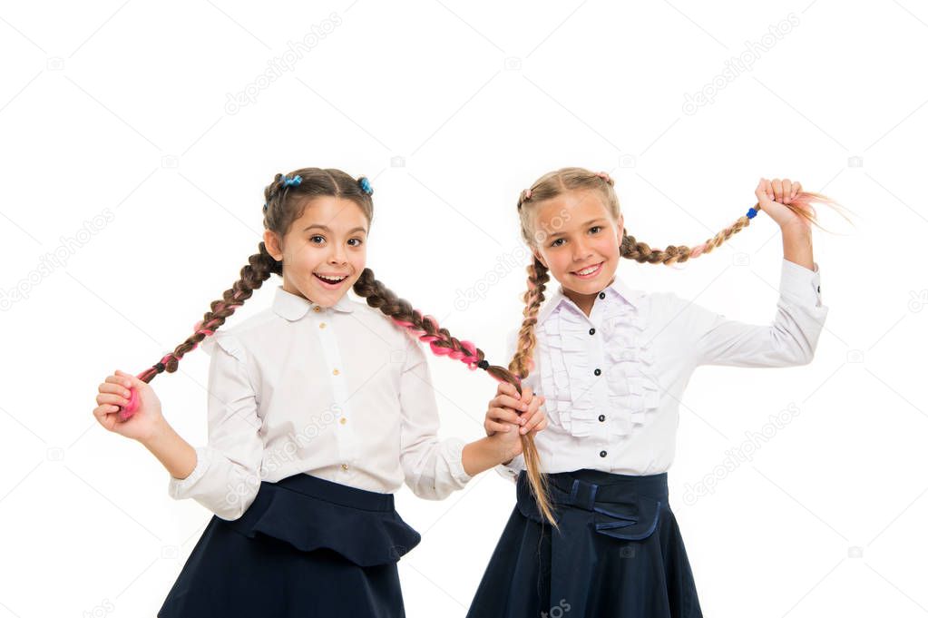 Helping hair grow faster. Adorable little children taking care of long hair. Cute small girl holding long hair braids isolated on white. Wearing long hair in plaits for school