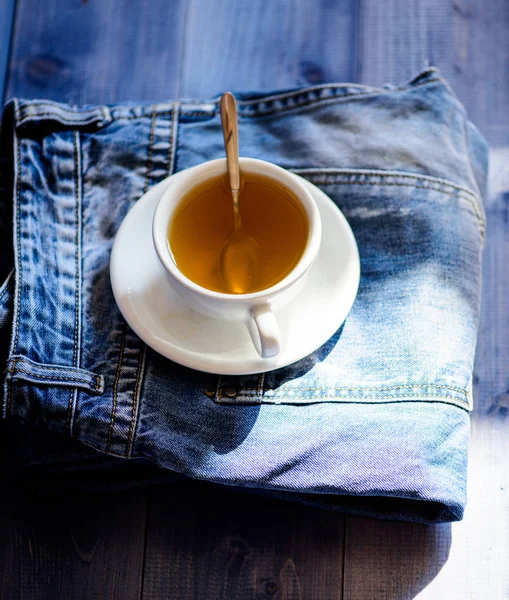 Caneca cheia de água fervente e saco de chá no fundo de calça azul. Processo de fabricação de chá em caneca de cerâmica. Plantas verdes ou pretas folha inteira. Hábitos saudáveis. Conceito de hora do chá. Copo caneca de água quente e saco de chá — Fotografia de Stock