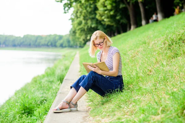 Ispirato da un autore di romanzi. Storia interessante. Rilassati e ottieni nuove informazioni. La lettura è il mio hobby. Studio estivo. donna nel parco a leggere un libro. studentessa con libro. diario scolastico per prendere appunti — Foto Stock