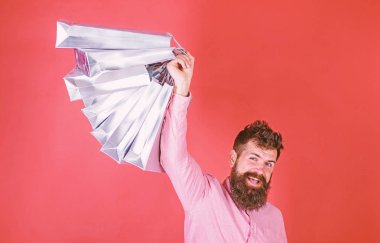 Satış sezon indirimlerle alışveriş adam. Sakal ve bıyık tutan alışveriş torbaları, kırmızı arka planı olan adam. Mutlu yüz hipster bağımlısı alışveriş veya Alışverişkoliğin. Alışveriş kavramı