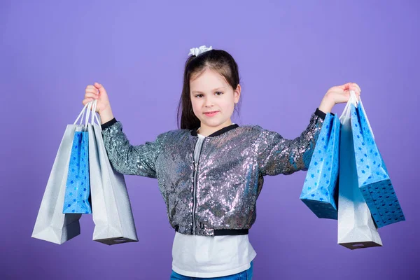 Día de compras. Paquetes de niños. Moda infantil. Regalo sorpresa. Grandes tiendas. Grandes opciones. Chica con bolsas de compras fondo violeta. Compras y compras. Descuento de venta. Viernes Negro —  Fotos de Stock