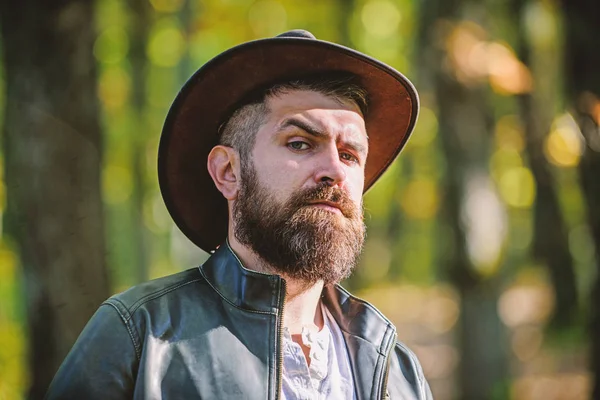 Adventures of cowboy. Man bearded cowboy nature background defocused. Brutal cowboy with long beard. Hipster tourist explore forest. Tourist hunter or gamekeeper. Masculinity and brutality concept — Stock Photo, Image