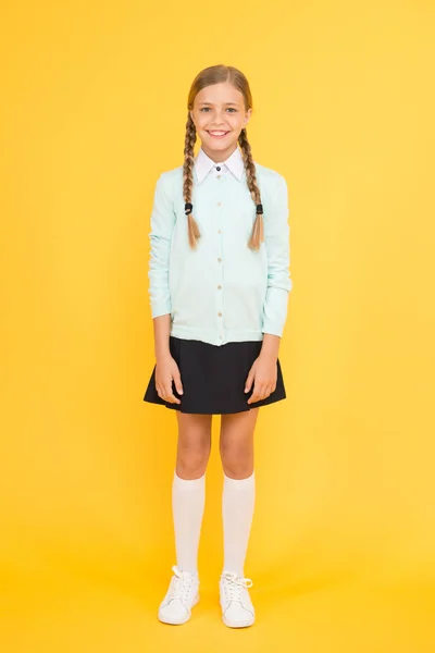 Le programme scolaire. fille heureuse en uniforme scolaire. retour à l'école. La mode des enfants. marché scolaire. concept d'éducation. journée de la connaissance. bonheur d'enfance. petite fille intelligente sur fond jaune — Photo