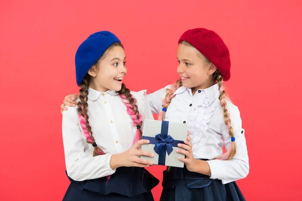 Sto facendo il regalo per te. Piccolo bambino carino che fa un regalo ad un amico su sfondo rosa. Adorabile bambina gode di dare il regalo alla compagna di scuola. Dare e ricevere vanno insieme — Foto Stock