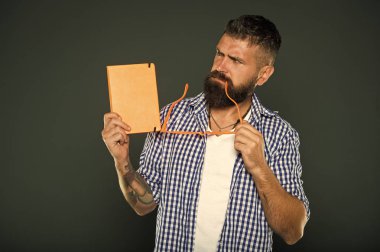 Düşüncesinde absorbe olma. Üniversite erkek öğrenci ders notları tutarak. Sakallı adam parti gözlük ve ders kitabı. İnek kitap ile çalışma. Süslü gözlük tutan kitap nerd
