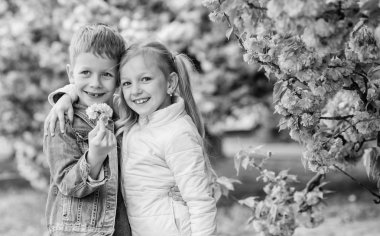 Romantik bebekler. Çocuklar pembe kiraz çiçeği zevk. Nazik aşk duyguları. Sakura ağacı arka plan çiçekler birkaç çocuk. Küçük kız bahar çiçekleri zevk. Ona tüm çiçekleri veriyorum. Onu şaşırtıcı