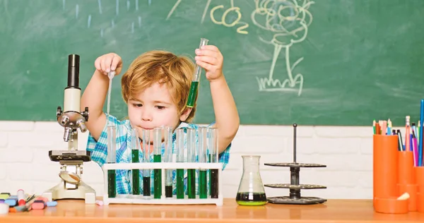 Studijní stipendia a stipendium. Dělá to chemický test. Wunderkind a raný vývoj. Malý žák učí chemii. Laboratoř chemie. Koncepce praktického poznání. Objevte kapaliny — Stock fotografie