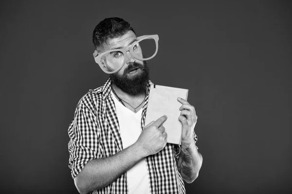 Εφιστώντας την προσοχή του εγχειριδίου. Σπασίκλα βιβλίο φορώντας φανταχτερά γυαλιά. Γενειοφόρος άνδρας κόμμα γυαλιά με το βιβλίο του μαθήματος. Μελέτη nerd που δείχνει δάχτυλο σε βιβλίο. Αρσενικό φοιτητής πανεπιστημίου με σημειώσεις διάλεξης — Φωτογραφία Αρχείου