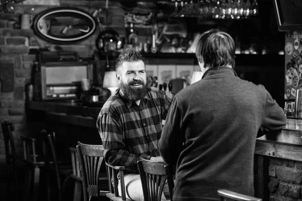 Helgen fritid. Fredag avkoppling i puben. Vänner avkopplande i pub. Vänlig konversation med främling. Hipster brutala skäggig man tillbringar fritid med vän bardisken i pub. Män avkopplande i pub — Stockfoto