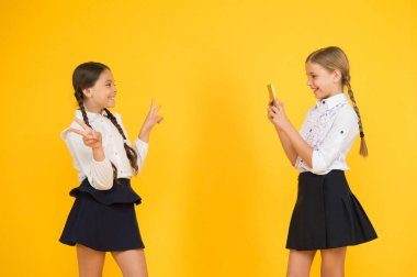 Blog yazıyorum. Okula dönüyorum. Eğitim blogu. Yeni teknoloji. Online eğitim. Bilgi günü. Akıllı telefonlu mutlu öğrenciler. Çocuklar fotoğraf çeker, arkadaşlık eder. Okul üniformalı küçük kızlar