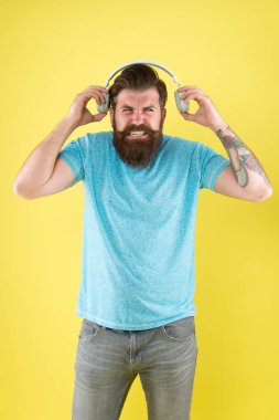 Korkunç bir ses. Hipster kırık kulaklıklar müzik Gadget dinle. Nefret dolu bir şarkı. Müzik tadı. Sakallı adam müzik sevmez. Rahatsız edici ses. Adam müzik kablosuz kulaklıklar dinlerken. Equalizer ayarları