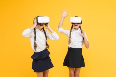 Yeni deneyimlerin tadını çıkar. Mutlu çocuklar modern teknolojiyi kullanır. Gelecekteki eğitim. Okula dönüyorum. Dijital gelecek ve yenilik. Sanal gerçeklik. VR kulaklıklı küçük kızlar. Çocuklar kablosuz VR gözlük takıyor