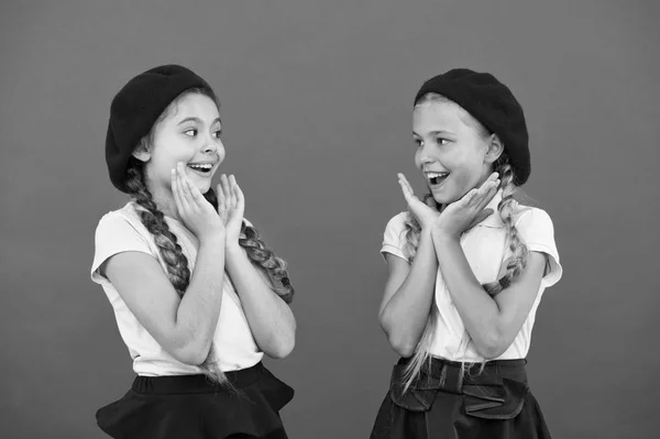 Son muy lindos. Chicas de estilo francés. Chicas con el mismo peinado. Niños pequeños con trenzas de pelo largo. Chicas de moda con el pelo atado en trenzas. Niños pequeños con boinas francesas elegantes —  Fotos de Stock