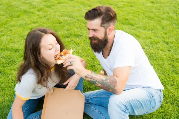 Pizza time. summer picnic on green grass. family weekend. couple in love dating. fast food. bearded man hipster and adorable girl eat pizza. happy couple eating pizza. feeding his girlfriend — Stock Photo, Image