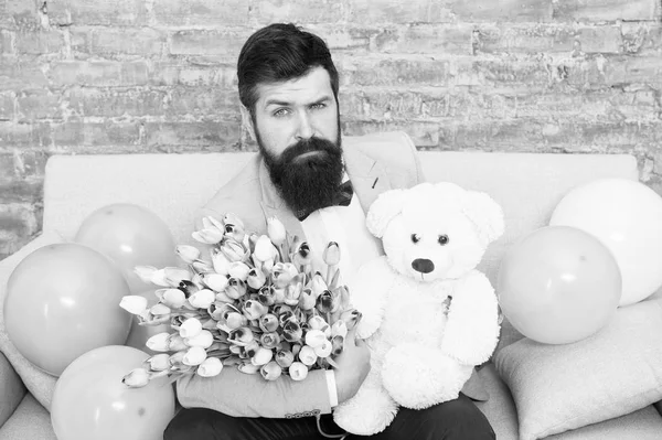 The flower experts. Spring gift. Bearded man hipster with flowers. Bearded man with tulip bouquet. March 8. Love date. international holiday. Womens day. Bearded man with tulips. Serious bearded man — Stock Photo, Image