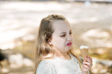It leaves a bad taste in the mouth. Cute little girl dislike taste of ice cream. Small child licking ice cream with unpleasant taste impression. Her ice-cream just doesnt taste as good clipart