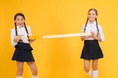 Yakın ya da uzak. Ölçme yetenekleri. Mesafeyi ölçüyorum. Ölçüm aletleri. Çocuklar matematik okuyor. Bilgi toplama günü. Okul üniformasında büyük bir cetvel var. Geometri dersi. Takım çalışması konsepti