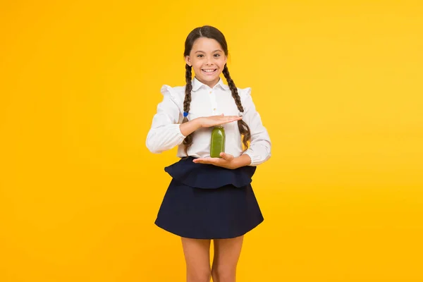 Dorst naar het leven. Thirsty schoolmeisje het houden van SAP fles op gele achtergrond. Dorstende dorst tijdens de schooltijd. Dorst en uitdroging. Dorst na kennis — Stockfoto