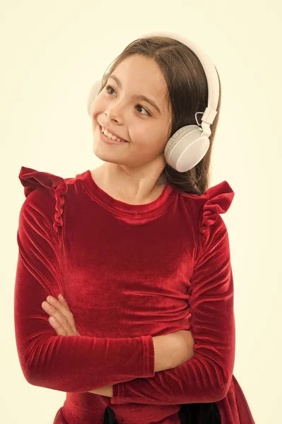 Estilo e música. infância e felicidade. menina pequena em vestido vermelho. moda infantil e beleza. criança pequena em fones de ouvido. música. a ouvir ebook. educação em áudio. dia feliz das crianças — Fotografia de Stock