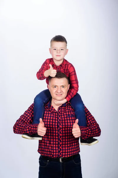 Father little son red shirts family look outfit. Best friends forever. Dad piggybacking adorable child. Having fun. Happiness being father of boy. Fathers day. Father example of noble human