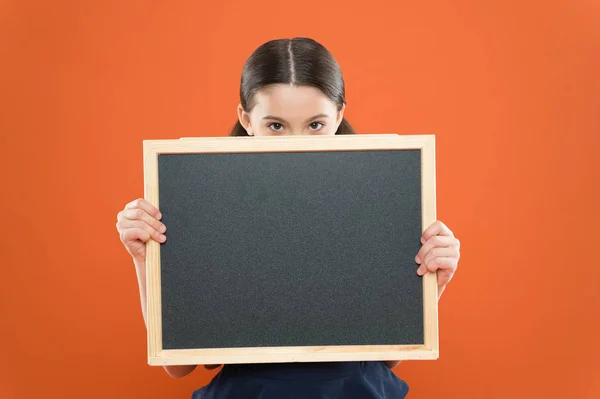 Sujet de la leçon d'aujourd'hui. Informations sur l'horaire scolaire. Une écolière tient un tableau noir. Concept d'actualités scolaires. Informer les enfants des changements dans la vie scolaire. Vérifier les responsabilités des élèves — Photo