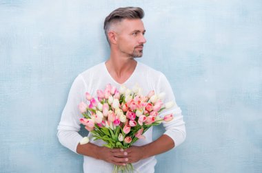 Onun için yumuşak laleler. Özel biri için. Lale buketli bir adam. Pembe laleler tutan yakışıklı bir adam. Çiçekli çekici bir adam. Seksi erkek sevgililer günü ya da doğum günü kutlaması için hediye taşır.