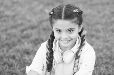 İyi tarafından bak. Secrets yükselterek mutlu bir çocuk için. Kız sevimli yeşil çim arka plan. Açık havada rahatlatıcı sağlıklı duygusal mutlu bir çocukluk. Kendinizi mutlu olsun. Kız modern kulaklık zevk rahatla