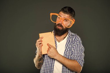 Onun el kitabı için dikkat çekmek. Kitap nerd süslü gözlük takıyorum. Adam ders kitabı ile parti bardaklarda sakallı. Çalışma kitabına parmakla inek. Üniversite erkek öğrenci ders notları ile
