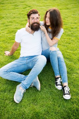 Mükemmel bir çift için mükemmel bir çift. Aşık bir çift sahne malzemesi gözlükleriyle eğleniyor. Bir çift sakallı adam ve yeşil çimlerin üzerinde seksi bir kadın. Aile çifti yaz günü dinleniyor.