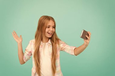 Merhaba dünya benim frekans bu. Selfie almama izin ver. Çocuk kız tutun smartphone. Görüntülü arama kavramı. Kız selfie alarak smartphone tutun. Sosyal ağlar için Selfie. Streaming online veya vlog çekim