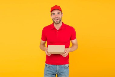 Kurye servis teslimatı. Satıcı ve kurye kariyeri. Kurye ve teslimat hizmeti. Postacı teslim işçisi. Mutlu adam sonrası paket sarı arka plan. Satın alma işlemini teslim etmek. Tatil için hediyeler