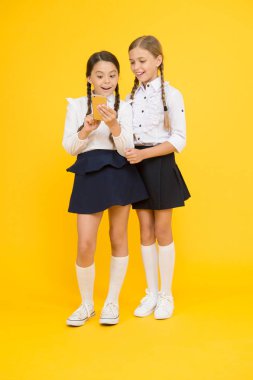 Akıllı telefon kullanan kızlar okulu üniforması. Öğrenci kızlar fotoğraf paylaşmak için cep telefonu ya da akıllı telefon kullanır. Okul başvurusu akıllı telefon. İnternet harika bir kaynak ama erişimin çocuklar için tehlikeleri var.