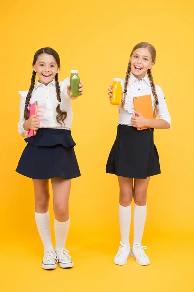 Gezond voedsel. dagboek en zuivel. Lunchtijd. Kleine meisjes met een boek. lezen en schrijven. gelukkige meisjes studeren met notitieblok. Literatuurles. terug naar school. Leerlingen drinken sap in de bibliotheek. gezondheid van kinderen — Stockfoto