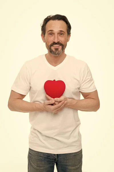 Romantică şi afectivă. Frumos om matur cu inima de Valentine zi. Îndrăgostiţii ţin inima roşie de jucărie în mâini. Probleme cardiace și asistență medicală. Prevenirea atacului de cord — Fotografie, imagine de stoc