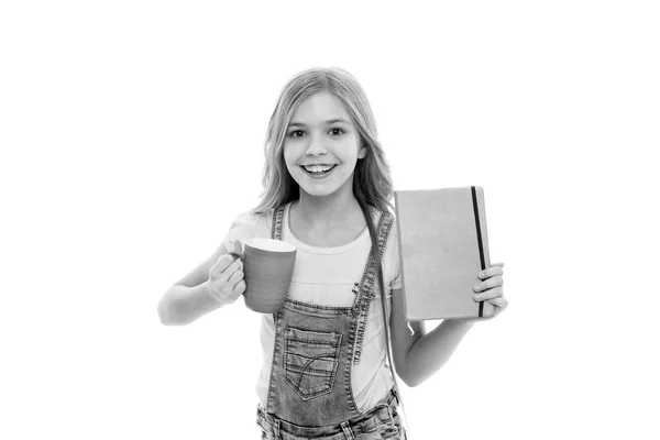 Launch your day with breakfast. Cute girl holding cup and note book. Small kid enjoying her school breakfast. Little baby drinking tea or milk for breakfast. Happy child having breakfast in morning — Stock Photo, Image
