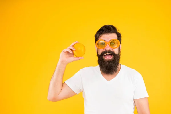L'arancia è ricca di vitamina C. Hipster contiene frutta vitaminica su sfondo giallo. Uomo barbuto con spuntino vitaminico sano. Vantaggi di mangiare cibo vitaminico, spazio copia — Foto Stock