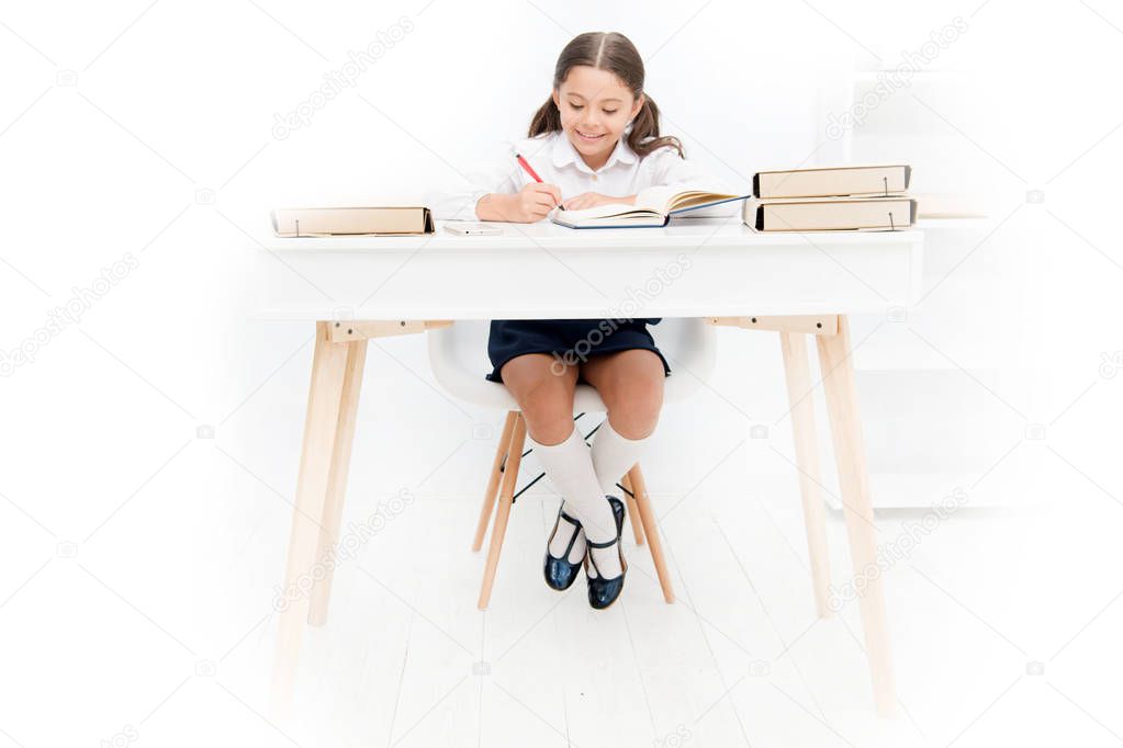 What should be height of study table. Schoolgirl doing homework at table. Adorable pupil little girl studying at table white background. Studying on desk with incorrect height can lead back pain