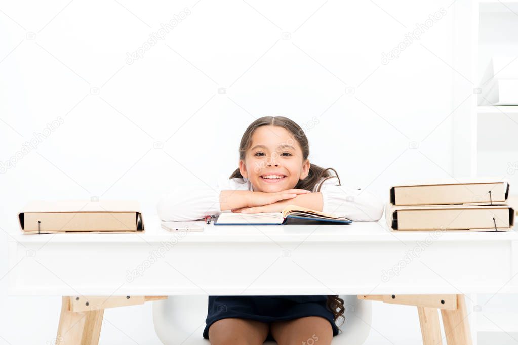 Studying on desk with incorrect height can lead back pain. What should be height of study table. Schoolgirl doing homework at table. Adorable pupil little girl studying at table white background