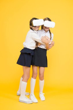 VR teknolojileri. Mutlu çocuklar modern teknolojiyi kullanır. Çocuklar kablosuz sanal gerçeklik gözlüğü takıyor. Sanal gerçeklik. VR kulaklıklı küçük kızlar. Gelecekteki eğitim. Okula dönüyorum. Dijital gelecek ve yenilik