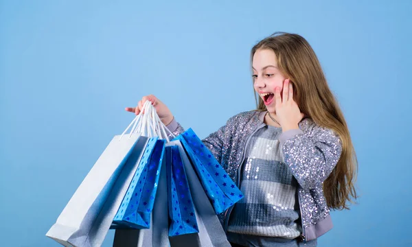 Chica moderna. Moda infantil. asistente de tienda con paquete. Ahorro de compra vacaciones. Ir de compras. Niña pequeña con bolsas de compras. Ventas y descuentos. Feliz niña. Niña con regalos. niño moderno —  Fotos de Stock