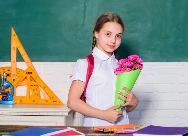 flower present for best teacher. knowledge day is 1 september. small school girl kid with flower bouquet. back to school. Happy teachers day. teachers day. pupil with flowers. childrens day