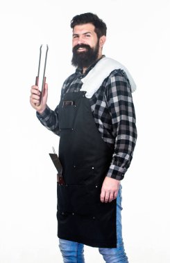 Keeping his hand far from flame. Bearded man holding barbecue tongs in hands. Grill cook using kitchen tongs. Chef hipster holding stainless steel tongs. Cooking tongs for preparing and serving food clipart
