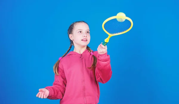 Loisirs actifs et passe temps. Tennis sport et divertissement. Fille adorable enfant jouer au tennis. Pratiquer le tennis et s'amuser. Super journée pour jouer. raquette de tennis enfant athlète sur fond bleu — Photo