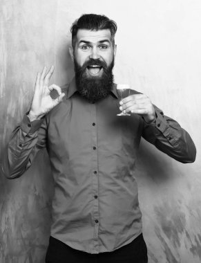 Sakallı adam, uzun sakallı. Kahverengi tişörtlü, bıyıklı, elinde kırmızı shot olan ve altın dokuda sorun yaratmayan, güler yüzlü, mutlu beyaz bir hippi.