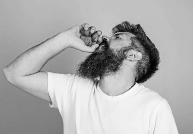 Sakallı hippi çilek suyu şişe içinde yumruk tutar. Taze meyve suyu kavramı. Adam içki çilek suyu mavi arka plan sakallı. Adam kesin yüz zevk ekstra taze içki çilek suyu