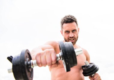 Kazanmak alışkanlıktır. Başarı seçimdir. Halter egzersiz salonu. Dambılla egzersiz icra eden kaslı bir adam. Güçlü gövdeli sporcu. Spor ekipmanları. Fitness ve vücut geliştirme sporu. Spor yaşam tarzı